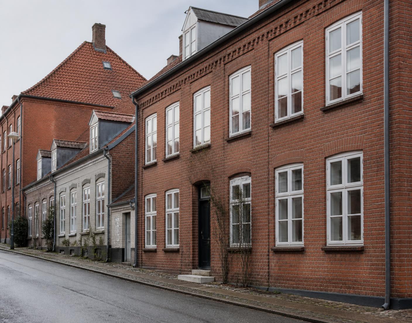 Rødstensejendom på en rolig gade i en jysk by